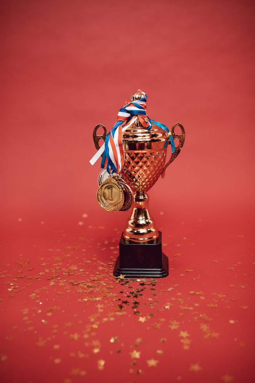 gold and blue trophy on red surface