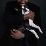 crop african american male holding dog